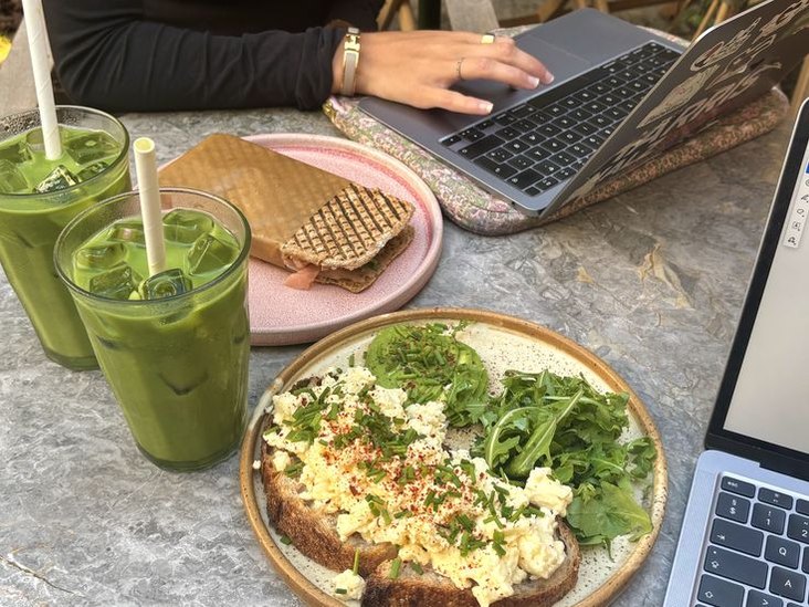 Breakfast at the laptop — scrambled eggs with rocket on sourdough and a green smoothie